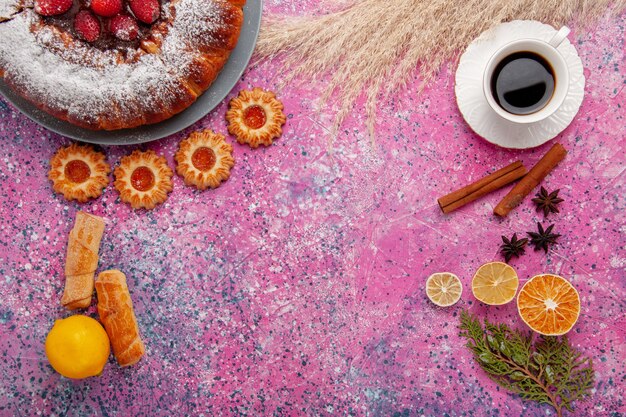 Draufsicht köstlicher Erdbeerkuchenzuckerpulverkuchen mit Keksen Zitrone und Tasse Tee auf rosa Hintergrundkuchen süßer Zuckerplätzchenkuchen