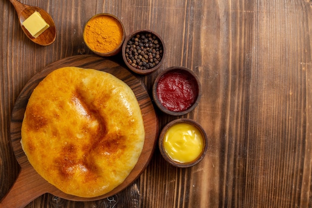 Draufsicht köstlicher gebackener Kuchen mit Kartoffelpüree und Gewürzen auf braunem hölzernem Schreibtischkuchen Hotcake Pie backen Teigmahlzeit