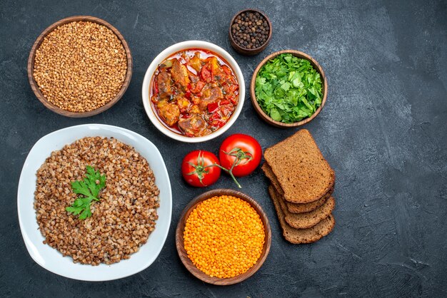 Draufsicht köstlicher gekochter Buchweizen mit Brot und Suppe auf dunklem Raum