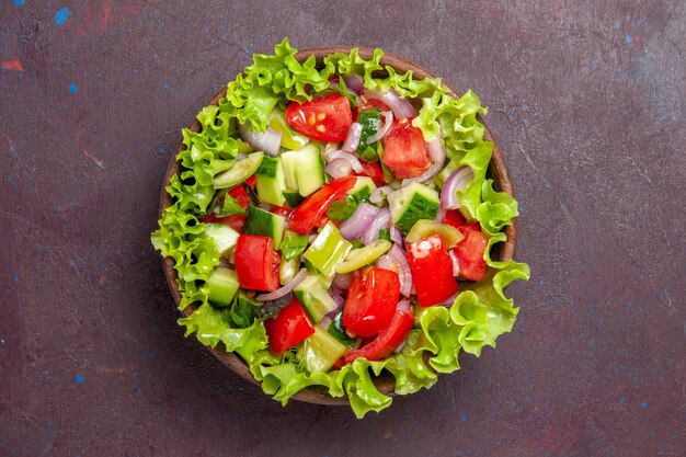 Draufsicht köstlicher Gemüsesalat in Scheiben geschnittenes Essen mit frischen Zutaten auf dunklem Hintergrund Salatmahlzeit Snack Mittagessen Lebensmittelfarbe