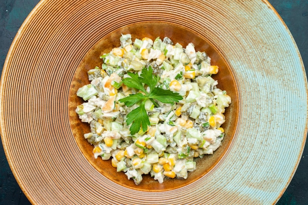 Draufsicht köstlicher Gemüsesalat innerhalb Platte auf dunkelblauem Schreibtisch.