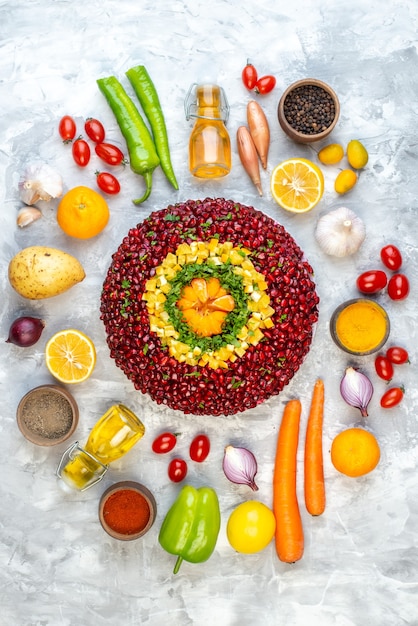 Draufsicht köstlicher Granatapfelsalat mit frischem Gemüse auf weißem Tisch