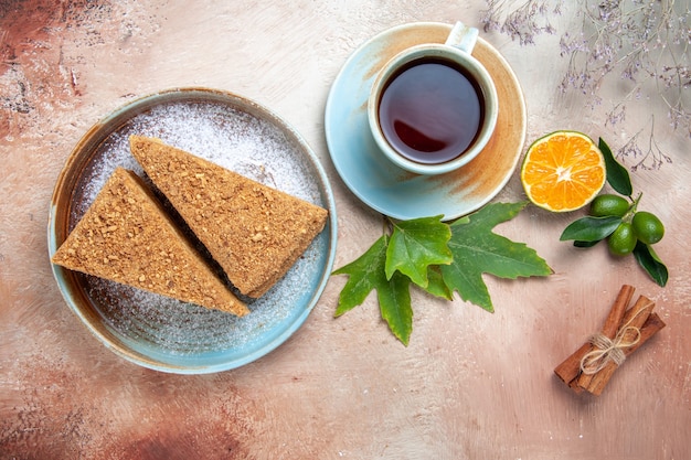 Draufsicht köstlicher Honigkuchen mit Tasse Tee auf hellem Schreibtischkuchenkuchen Keks süß