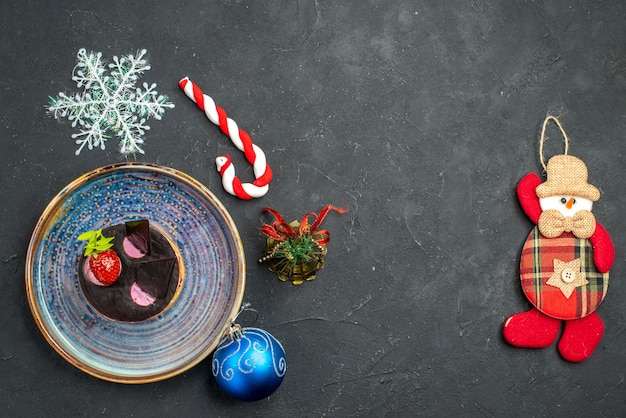 Draufsicht köstlicher Käsekuchen mit Erdbeere und Schokolade auf Tellerweihnachtsdetails auf dunklem, isoliertem Hintergrund