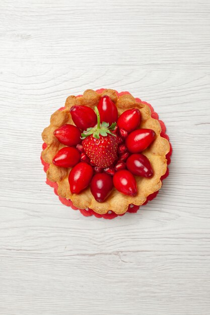 Draufsicht köstlicher kleiner Kuchen mit Früchten auf weißem Schreibtisch