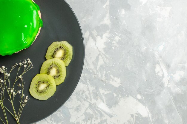 Draufsicht köstlicher kleiner Kuchen mit grünem Zuckerguss innerhalb Platte auf weißem Hintergrundkuchen bisciut süßer Zuckerkuchen