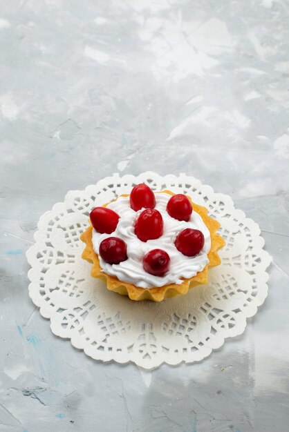 Kostenloses Foto draufsicht köstlicher kleiner kuchen mit sahne und roten früchten auf der grauen oberfläche süße frucht