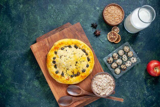 Draufsicht köstlicher Kuchen mit Eiern und Milch auf dunkelblauer Oberfläche