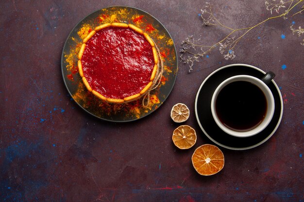 Draufsicht köstlicher Kuchen mit roter Sahne und Tasse Kaffee auf den dunklen Hintergrundkekskuchen-Zuckerdessertkuchen-süßen Keksen