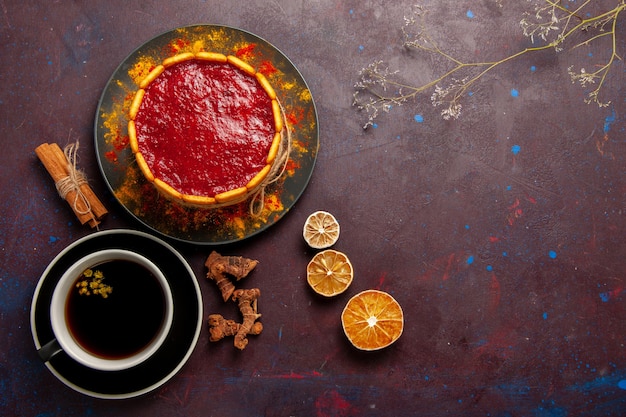 Draufsicht köstlicher Kuchen mit roter Sahne und Tasse Kaffee auf dunklem Schreibtischkekskuchenzuckerdessertkuchen süße Kekse