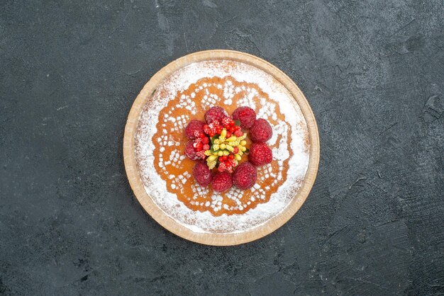 Draufsicht köstlicher Kuchen mit Zuckerpulver und Himbeeren auf dem grauen Hintergrund Tortenkuchen Fruchtbeeren süßer Keks