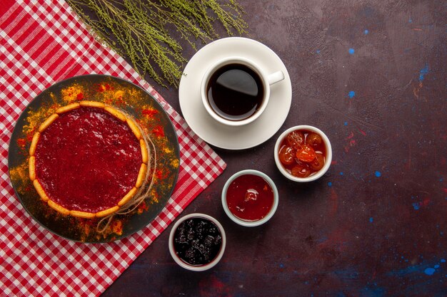 Draufsicht köstlicher Nachtischkuchen mit Tasse Kaffee und Fruchtmarmeladen auf dunklem Hintergrundkekszuckerplätzchen süßer Kuchen Nachtisch