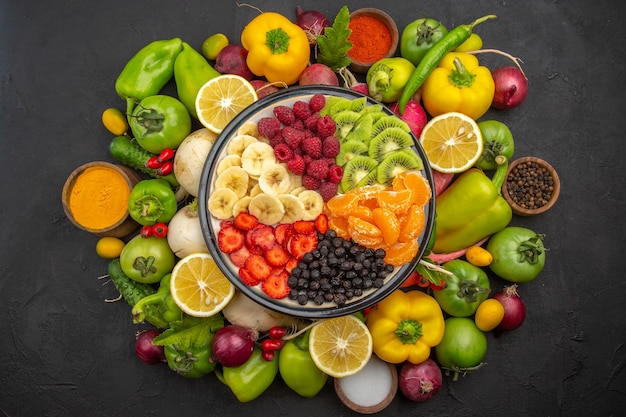 Draufsicht köstlicher Obstsalat innerhalb des Tellers mit frischen Früchten auf einem exotischen reifen Diätfoto des dunklen tropischen Obstbaums