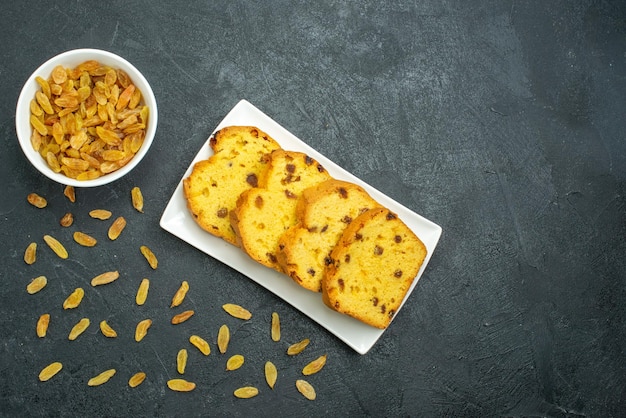 Draufsicht köstlicher Rosinenkuchen mit frischen Rosinen auf dunkler Oberfläche süßer Kuchenkekskuchentee