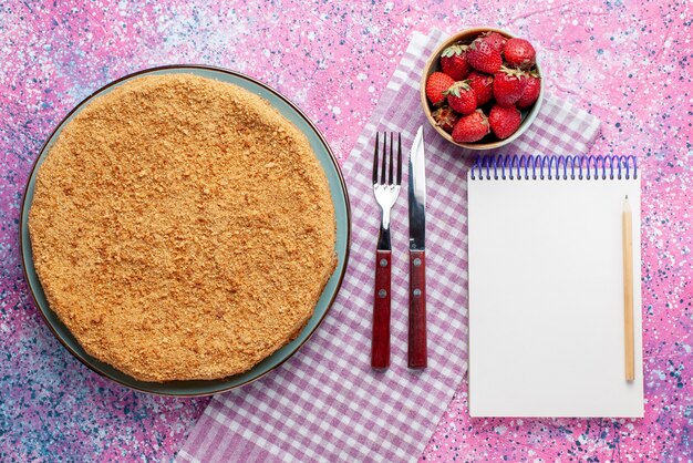 Draufsicht köstlicher runder Kuchen innerhalb Platte mit Erdbeeren auf hellrosa Schreibtischkuchen Kuchenkeks süßer Backzucker