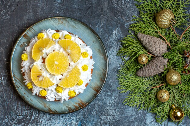 Draufsicht köstlicher Sahnekuchen mit geschnittenen Früchten und Zapfen