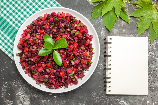 Draufsicht köstlicher Vinaigrette-Rübensalat innerhalb Platte auf dunkler Oberfläche