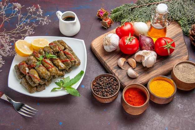 Draufsicht köstliches Blatt-Dolma mit frischem Gemüse und Gewürzen auf dem dunklen Hintergrund-Mahlzeitgericht Blattfleisch-Abendessen-Essen