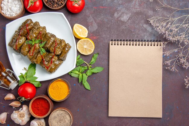 Draufsicht köstliches Blatt-Dolma mit Gewürzen und Tomaten auf dem dunklen Hintergrundtellerblatt-Fleischabendessen