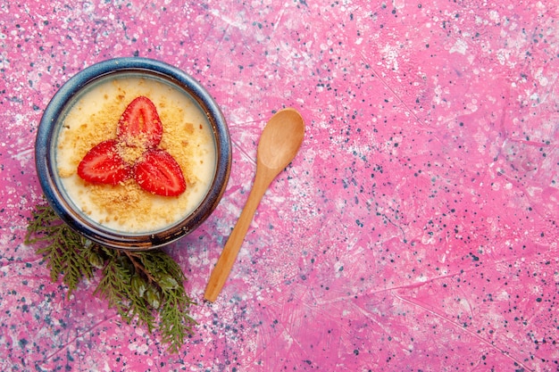 Kostenloses Foto draufsicht köstliches cremiges dessert mit rot geschnittenen erdbeeren innerhalb platte auf hellrosa hintergrund dessert eiscreme farbe süße frucht beere