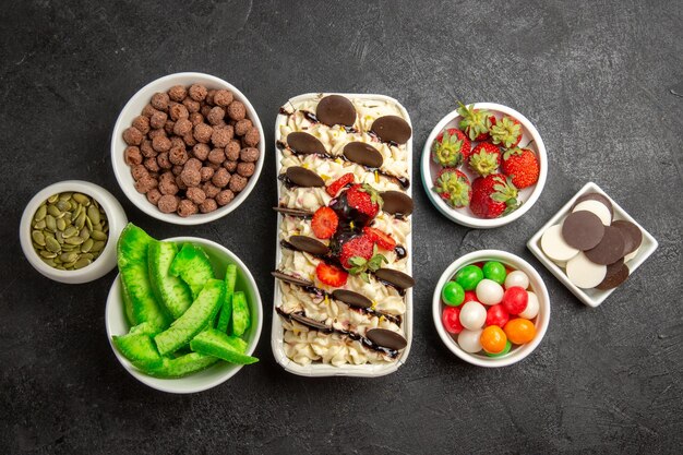 Draufsicht köstliches Dessert mit Fruchtkeksen und Bonbons auf dunklem Hintergrund Bonbonfarben Keks süße Kekse