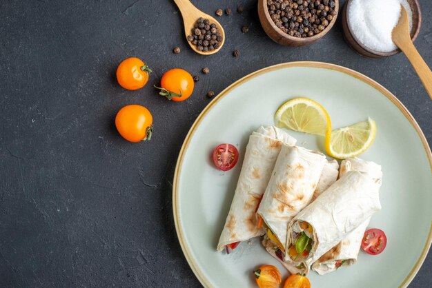 Draufsicht köstliches Döner in Scheiben geschnittenes Pita-Sandwich im Teller auf dunkler Oberfläche