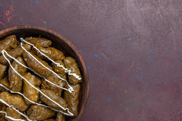 Draufsicht köstliches dolma östliches Gericht mit Blättern und Hackfleisch im Inneren auf dunklem Hintergrund Ölkalorien Abendessen Fleischessen