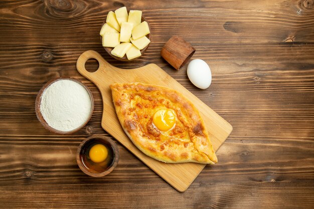 Draufsicht köstliches Eierbrot, das auf einem braunen hölzernen Schreibtisch gebacken wird