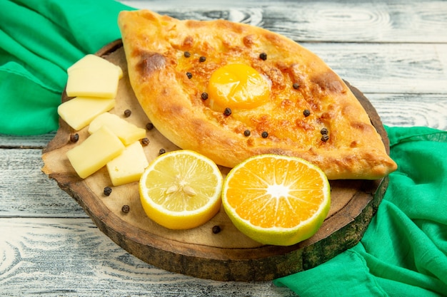 Draufsicht köstliches Eierbrot, das mit Käse auf einem rustikalen grauen Schreibtisch gebacken wird