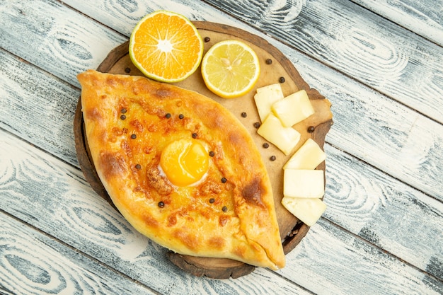 Draufsicht köstliches Eierbrot, das mit Käse auf rustikalem Schreibtisch gebacken wird