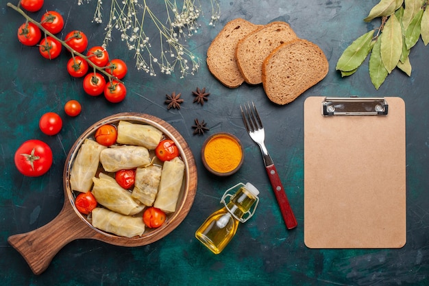 Kostenloses Foto draufsicht köstliches fleischmehl, das in kohl mit ölbrot und frischen tomaten auf dunkelblauem schreibtischfleischnahrungsmittelabendessen-gemüsegericht gekocht wird