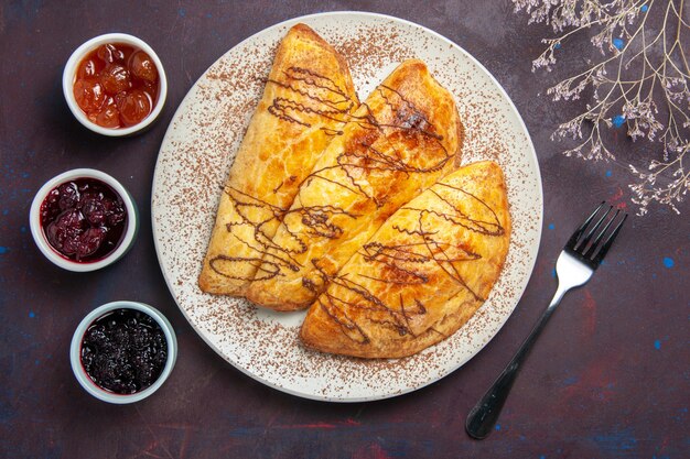 Draufsicht köstliches gebackenes Gebäck mit Marmelade auf dunklem Raum