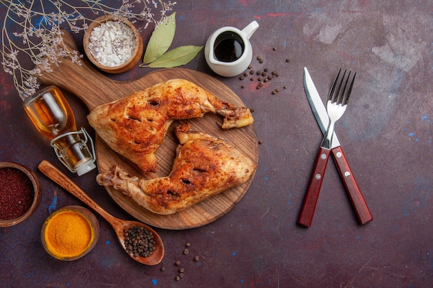 Draufsicht köstliches gebratenes Huhn mit verschiedenen Gewürzen auf dem dunklen Raum