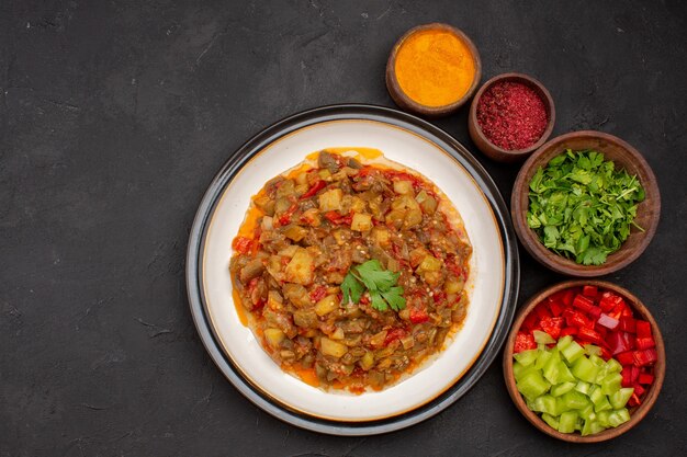 Draufsicht köstliches Gemüsegericht gekocht mit Gewürzen und Grün auf grauem Hintergrundsalatmahlzeit, das Speiseölsauce kocht