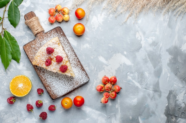 Draufsicht köstliches leckeres Kuchenstück mit Früchten auf dem weißen Schreibtischzuckerkuchenkeks