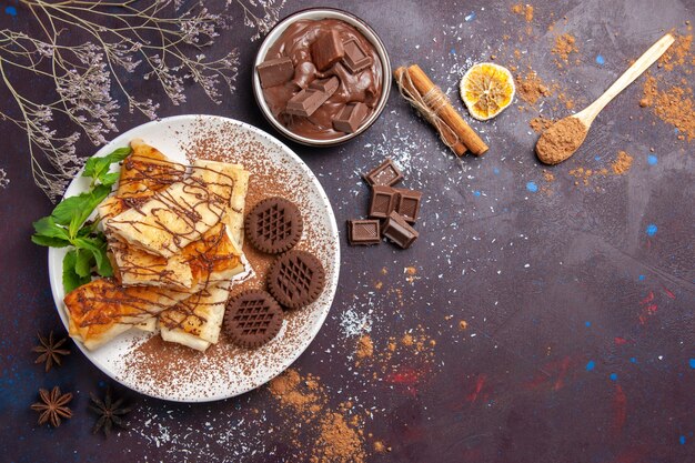 Draufsicht köstliches süßes Gebäck mit Schokoladenplätzchen auf dunklem Bodenkuchenzuckerkekstee süßes Dessert