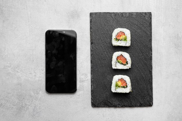 Draufsicht köstliches Sushi und Smartphone