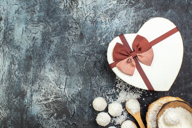 Kostenloses Foto draufsicht kokosbonbons mit geschenk auf grauem hintergrund tee urlaub rotes liebespaar goodie valentinstag geschenk farbe süßer freier ort