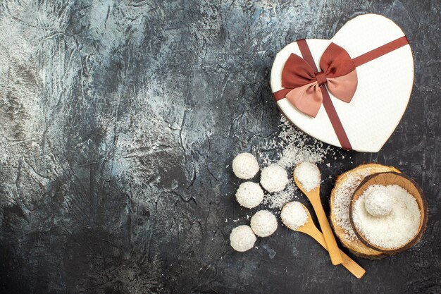 Draufsicht Kokosbonbons mit Geschenk auf grauem Hintergrund Urlaub rotes Liebespaar Goodie Valentinstag Tee Geschenk Farbe süßer Freiraum