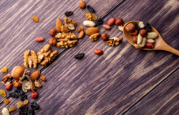 Draufsicht kopieren Raum Holzlöffel mit Nüssen und Rosinen Erdnüssen und Mandeln auf einem Holztisch