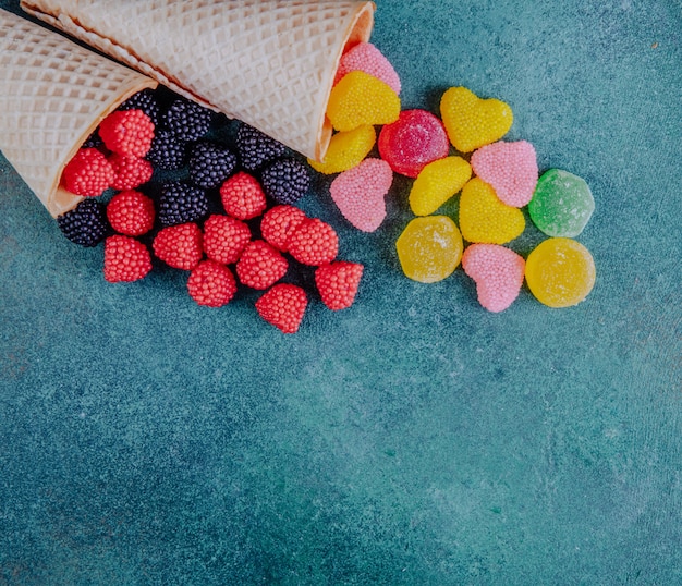 Draufsicht kopieren Raummarmelade in der Form von Himbeeren Brombeeren und Herzen mit Waffelkegeln auf einem dunkelgrünen Hintergrund