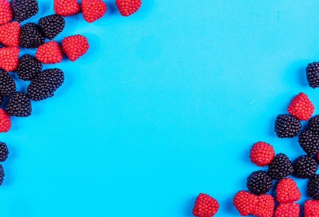 Draufsicht kopieren Raummarmelade in Form von Himbeeren und Brombeeren auf einem blauen Hintergrund