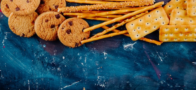 Kostenloses Foto draufsicht kopieren raumplätzchen und grissini auf einem blauen hintergrund