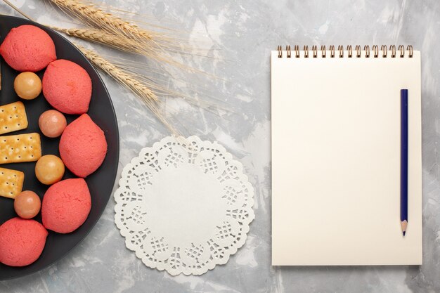 Draufsicht Kuchen und Bagels mit Bonbons und Crackern innerhalb Platte auf weißem Schreibtisch Kuchen Keks Keks Zucker süße Torte