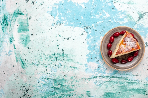 Kostenloses Foto draufsicht-kuchenscheibe mit frischen roten hartriegeln auf hellblauem hintergrundfruchtkuchen backen kuchenzuckerkeks süß