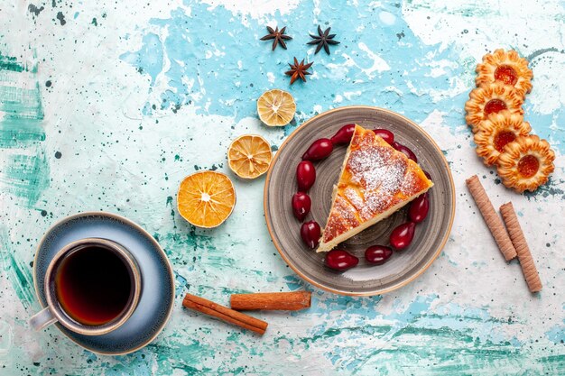 Draufsicht-Kuchenscheibe mit Keksen und Tasse Tee auf blauem Oberflächenfruchtkuchen backen Kuchenkeks süß