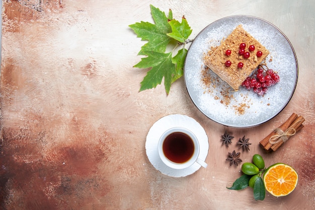 Draufsicht Kuchenscheibe mit Tee und roten Beeren auf hellem Bodenkuchen Keks süß