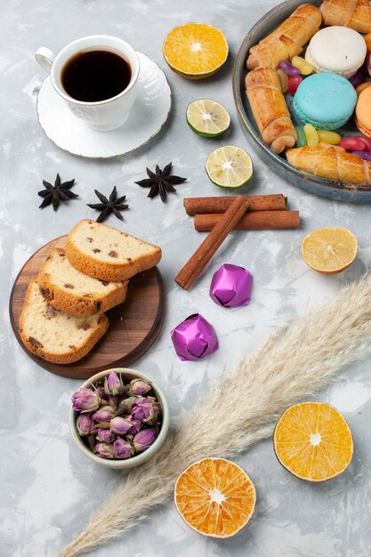 Draufsicht-Kuchenscheiben mit Süßigkeiten und Tasse Tee auf Weiß