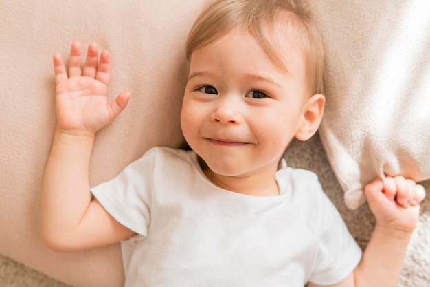 Draufsicht lächelndes Baby auf Kissen