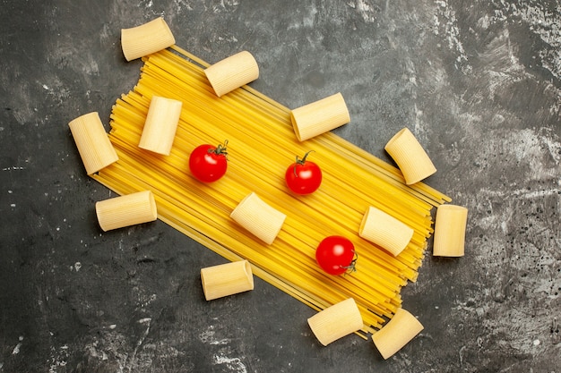 Draufsicht lange italienische Pasta mit roten Tomaten auf hellgrauem Hintergrund